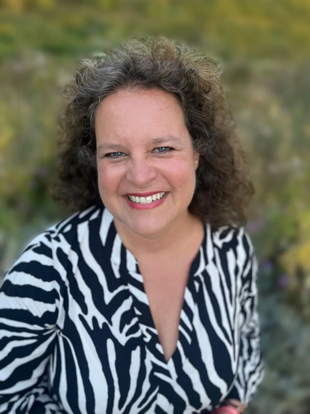 Birgit Fleissner lächelt im Grünen in die Kamera.